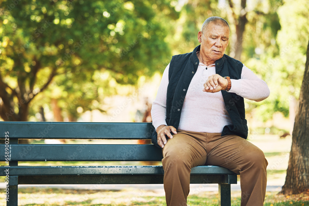 Check, watch and senior man outdoor in nature, park or planning activity in retirement schedule. Reading, time and elderly person sitting on bench in woods, environment or forest with technology