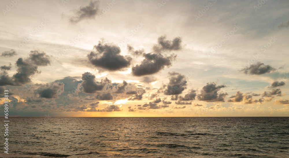 Sea sunset with cloudy sky and sun through the clouds over. Clouds Ocean and sky background, seascape.