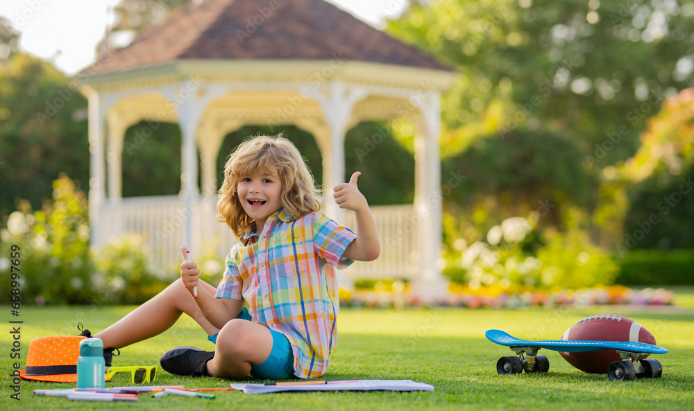 Summer leisure with children. Child artist paints creativity vacation. Kid boy draws in park laying in grass having fun on nature background.