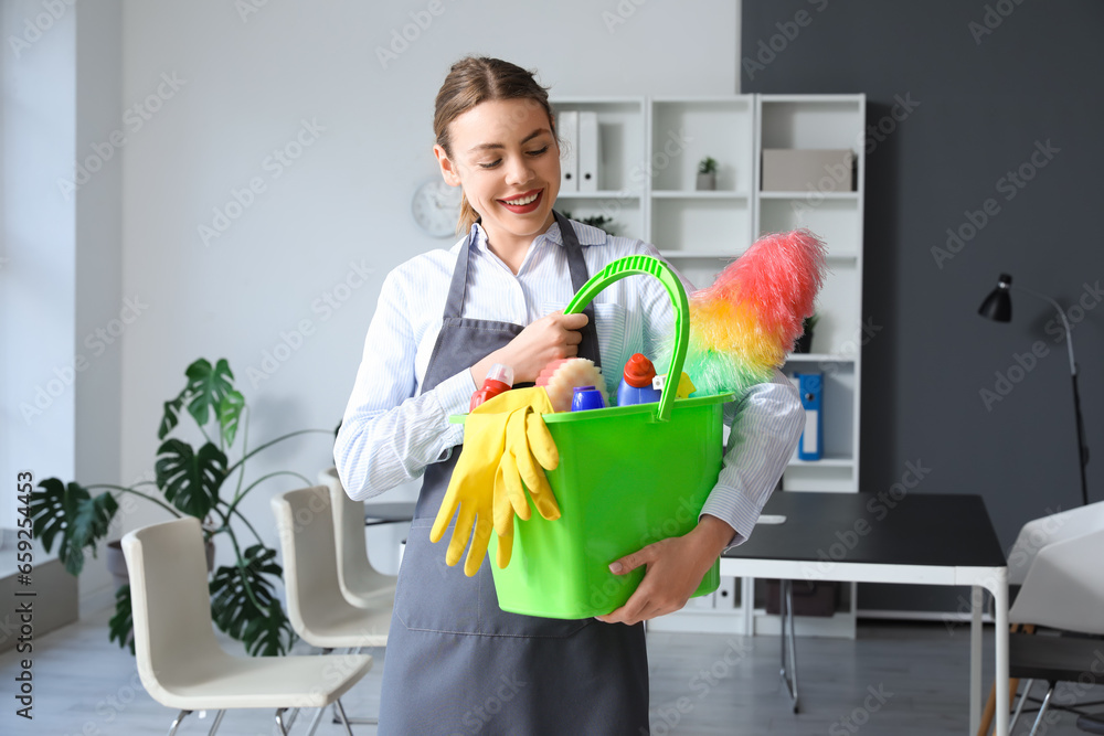 Female janitor with cleaning supplies in office