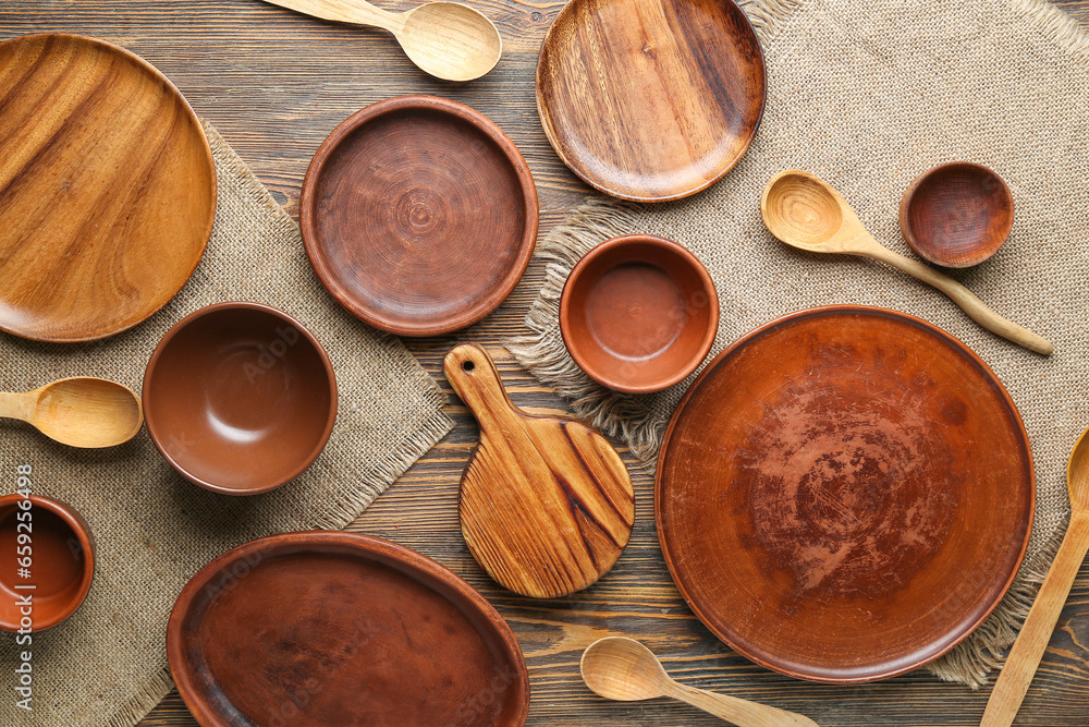 Set of clean bowls, spoons and plates on wooden table