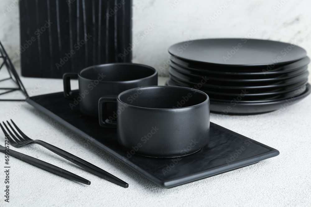 Set of black ceramic tableware on white table