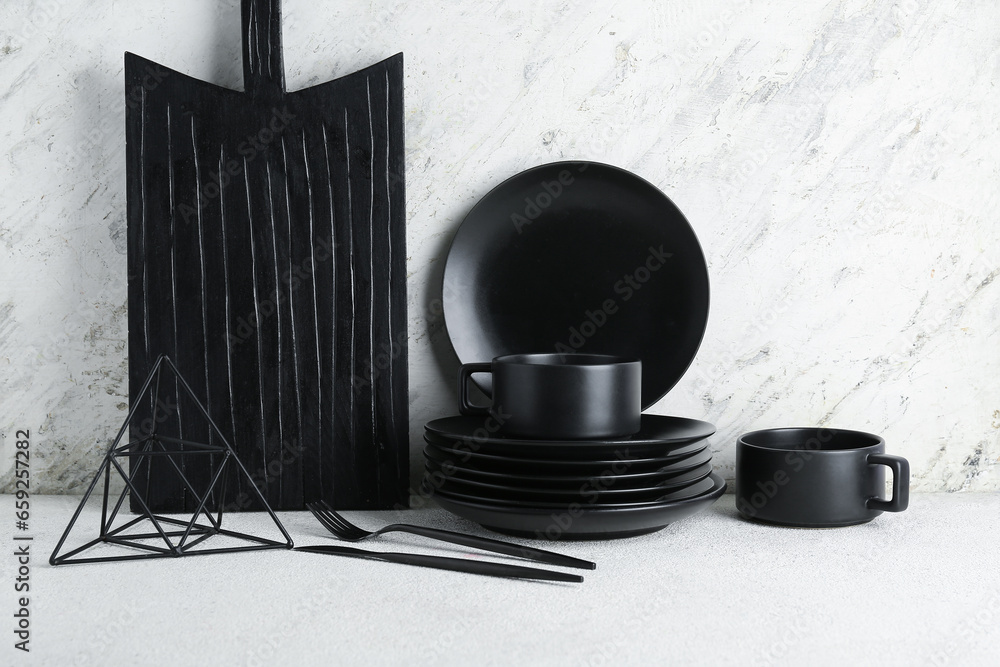 Set of black ceramic tableware on white table