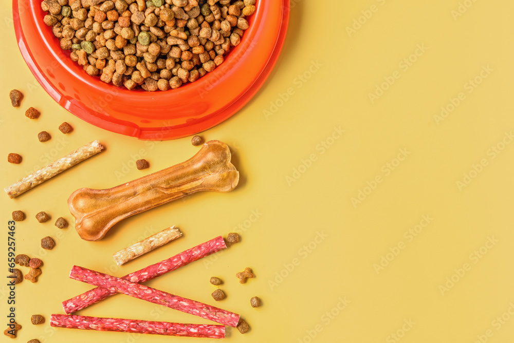 Composition with dog treats and dry food on color background