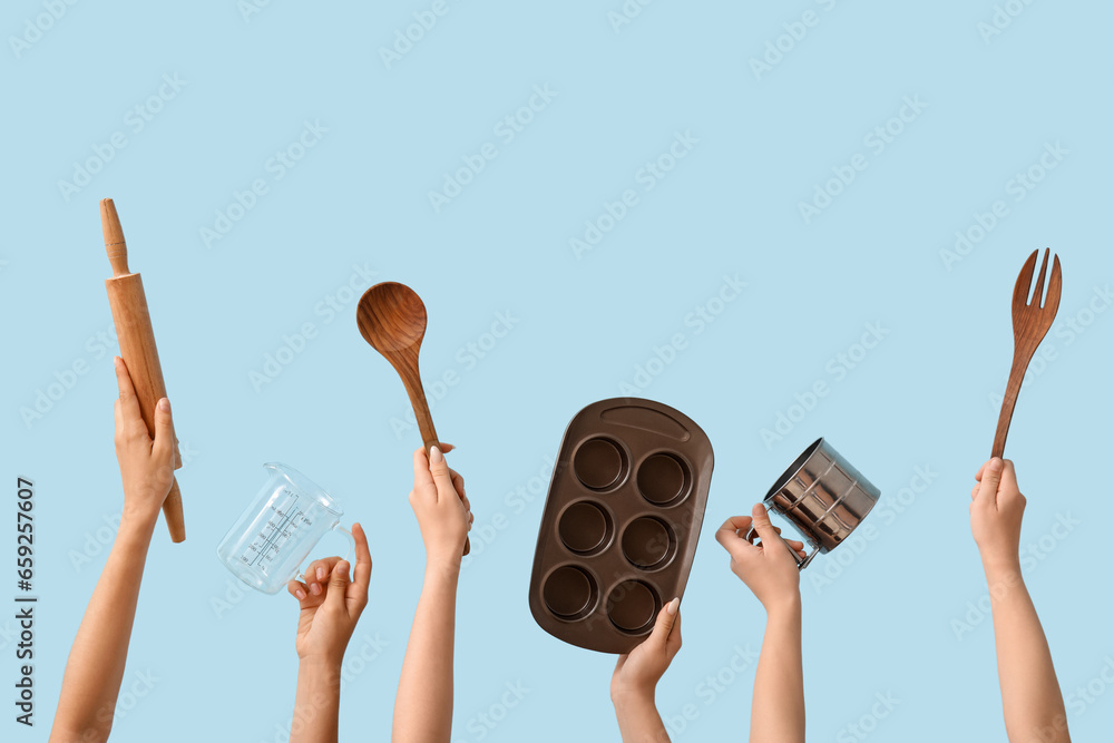 Female hands with baking utensils on blue background