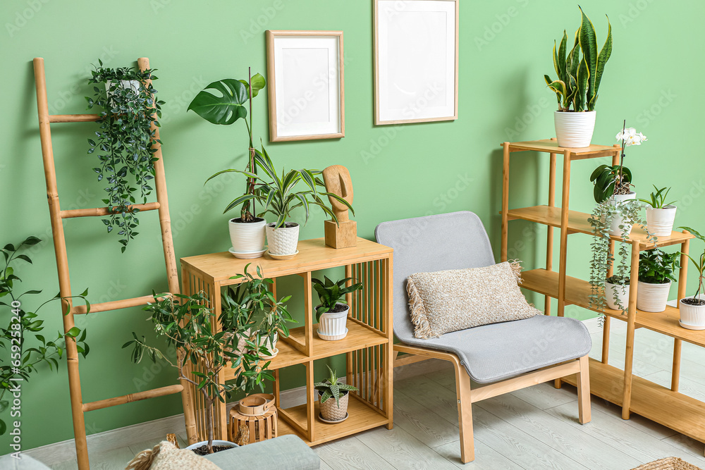 Grey armchair and wooden shelving units with houseplants in interior of modern living room