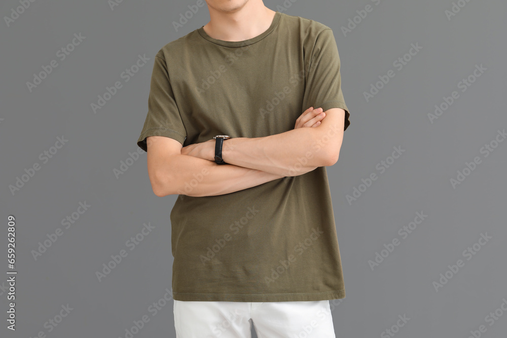 Man in stylish green t-shirt on grey background