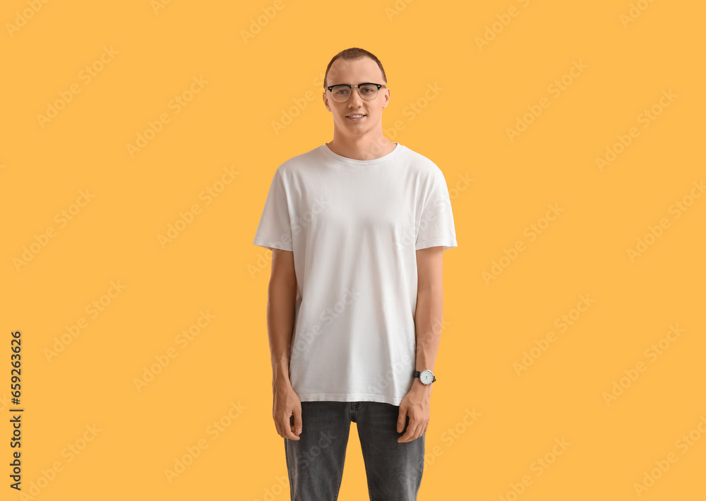 Handsome young man in stylish t-shirt on orange background