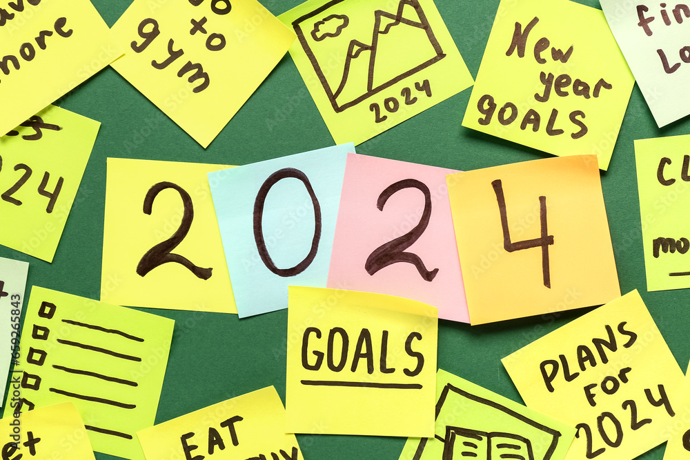 Sticky notes with different goals for 2024 on green background