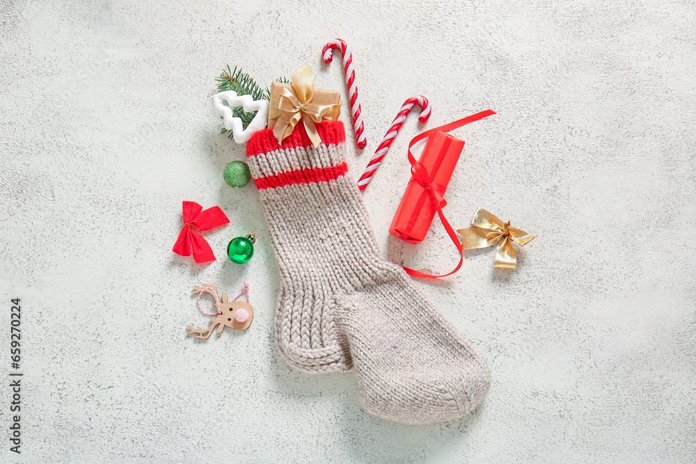 Christmas sock with beautiful decorations and gift boxes on white background