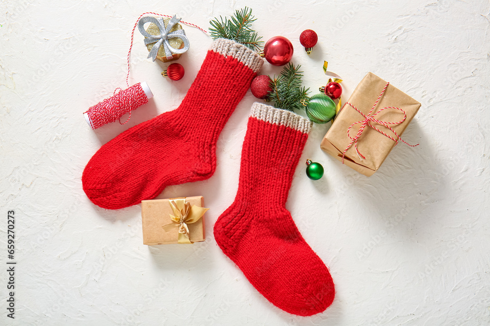 Christmas socks with tree branches, balls and gift boxes on white background