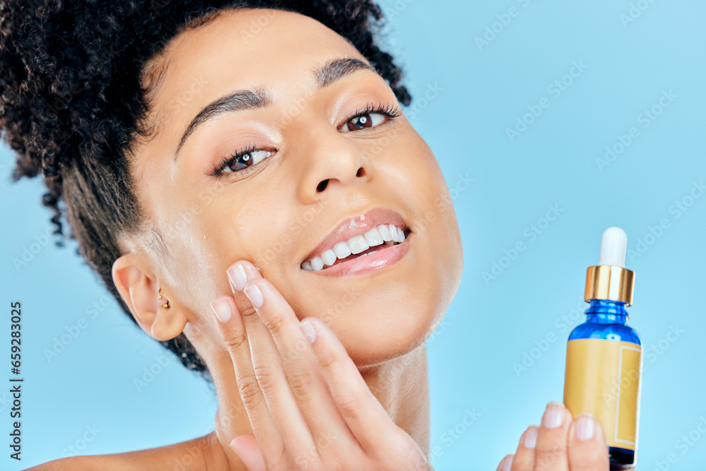 Beauty serum, portrait and woman with bottle, container and apply collagen, essential oil or retinol for skin hydration. Cosmetics face product, facial skincare and studio person on blue background