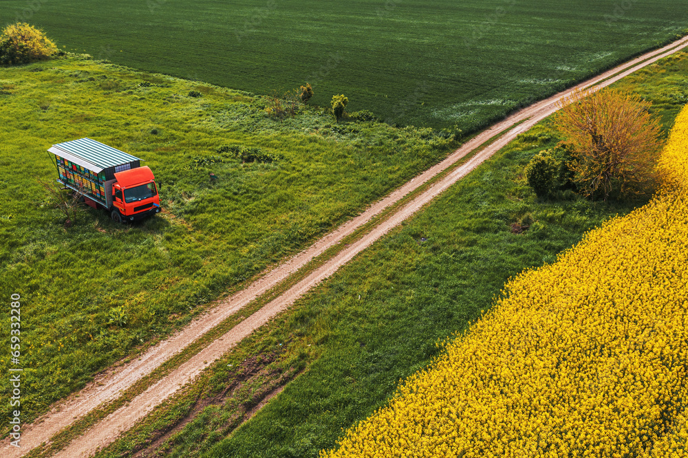 Aerial shot of apiary truck with colorful beehive wooden crates in trailer