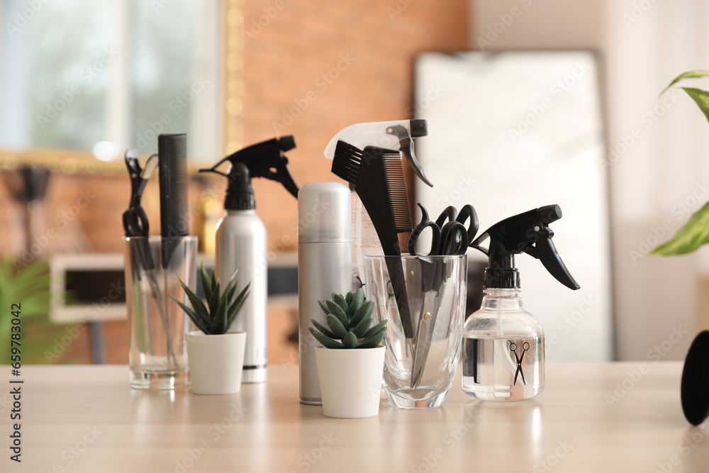 Hairdressing tools with succulents on table in beauty salon