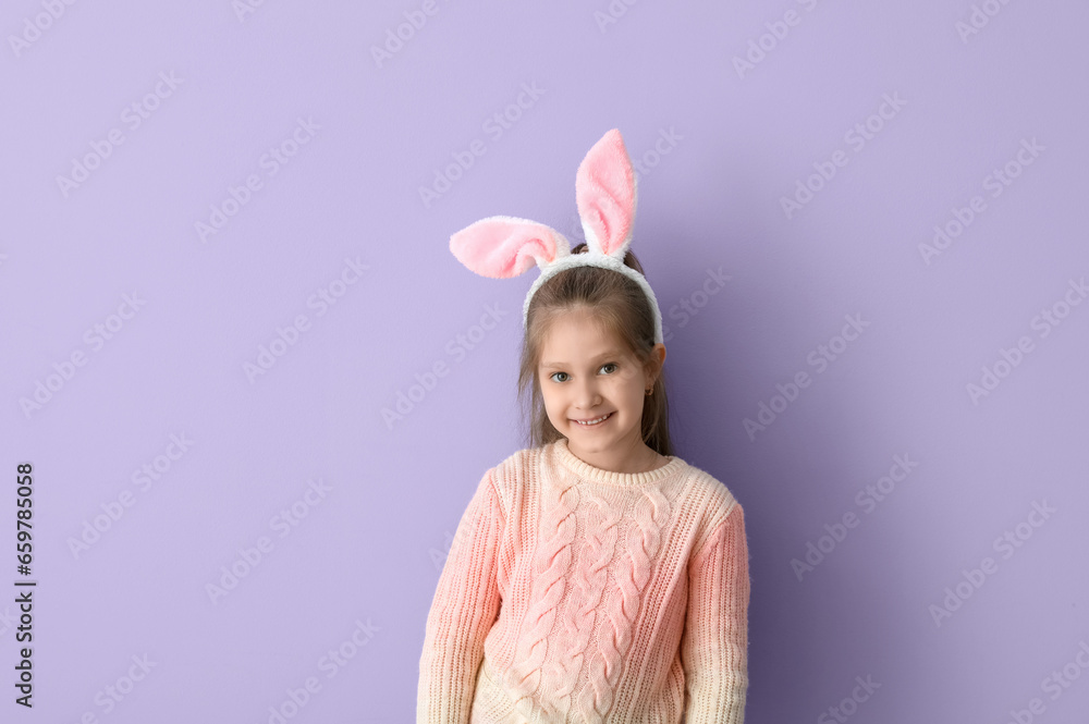 Cute little girl in bunny ears and knitted sweater on lilac background