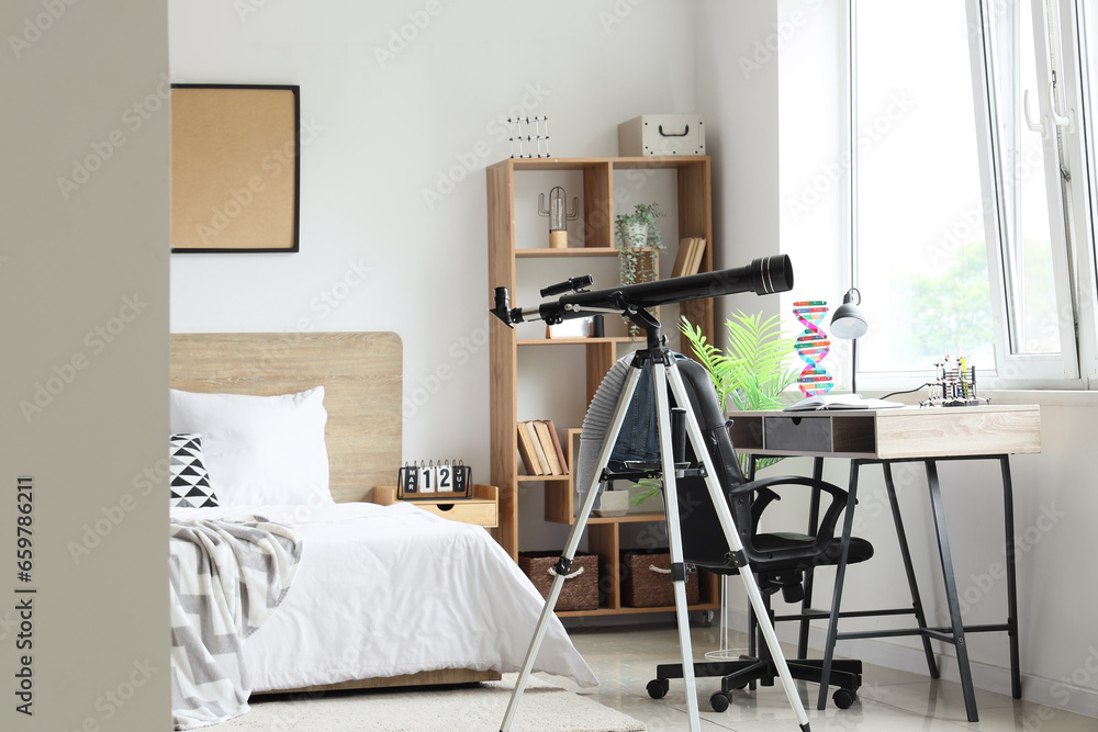 Interior of childrens bedroom with telescope, desk and cozy bed