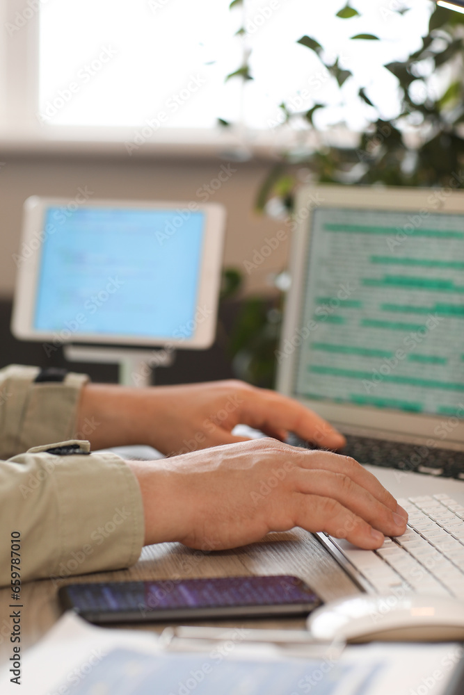 Male programmer working at table in office, closeup