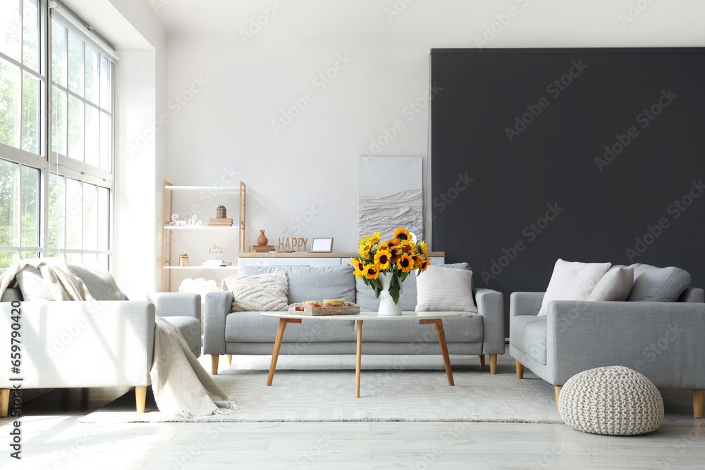 Interior of living room with sunflowers in vase and breakfast on table