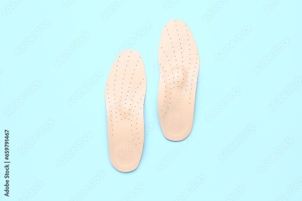 Leather orthopedic insoles on color background