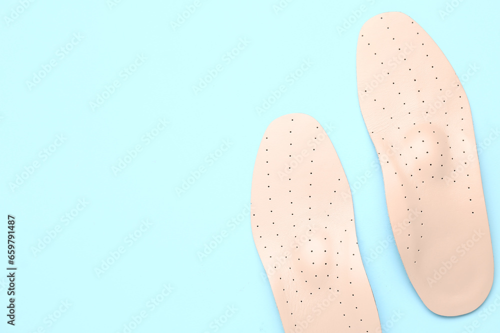 Leather orthopedic insoles on color background