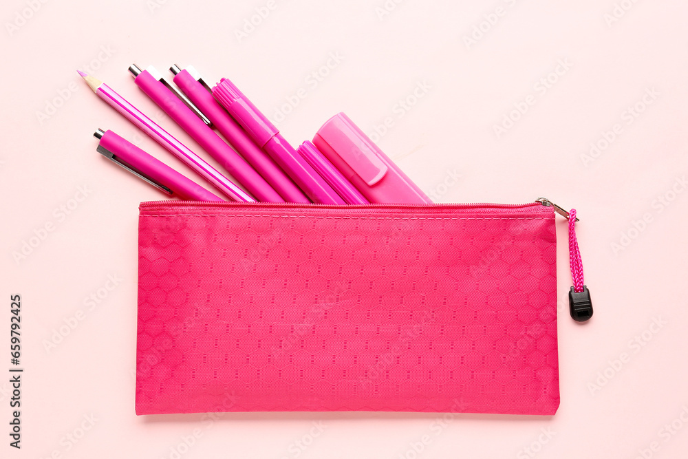 Stylish pencil case with different school stationery on pink background