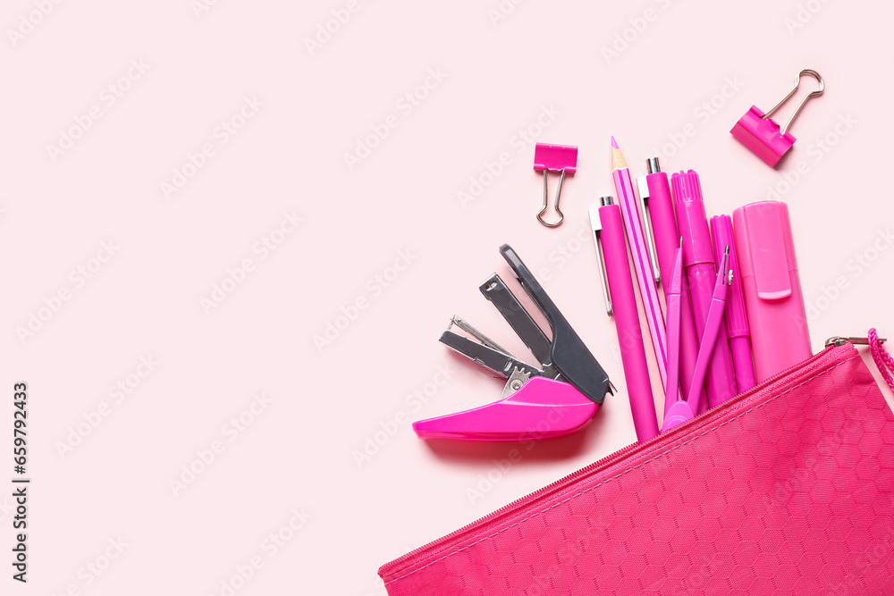 Stylish pencil case with different school stationery on pink background