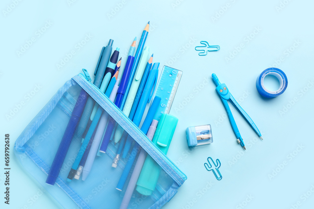 Stylish pencil case with different school stationery on blue background