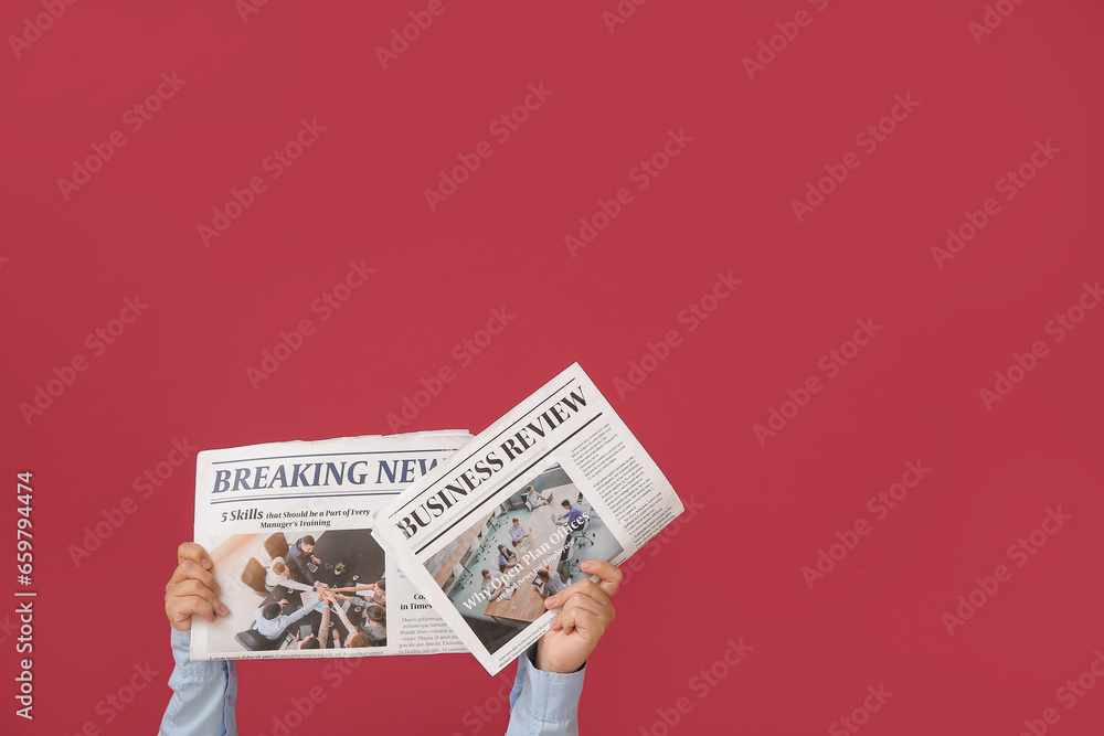 Woman holding newspapers on color background