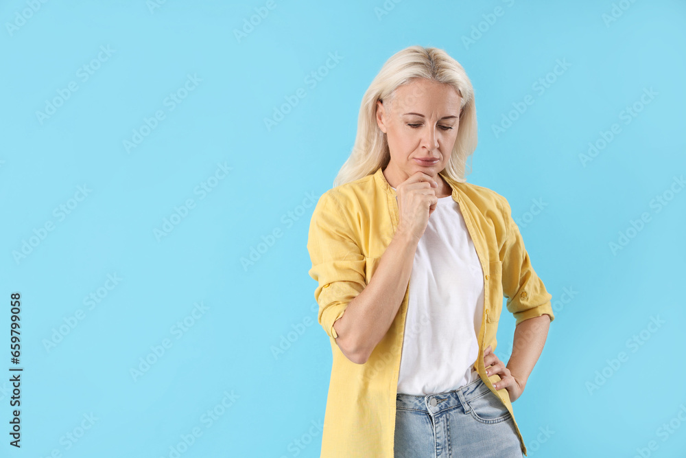 Thoughtful mature woman on blue background