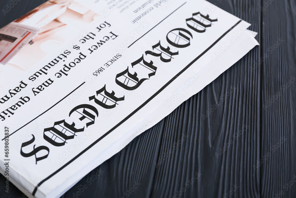 Morning newspaper on black wooden background