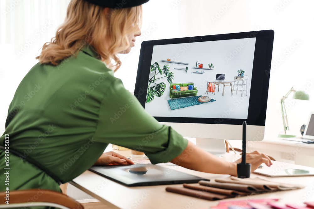 Female interior designer working with graphic tablet at table in office