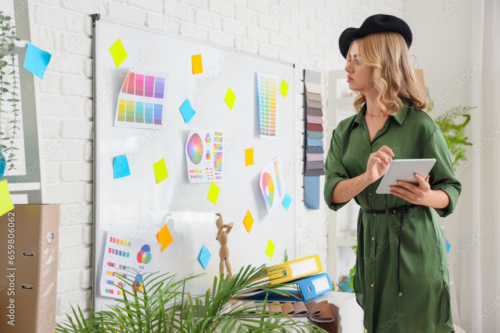 Female interior designer working with tablet computer in office