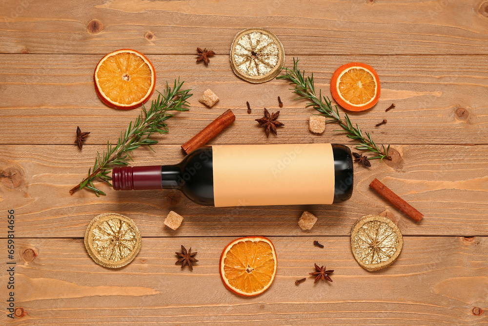 Bottle of wine and different spices on wooden background