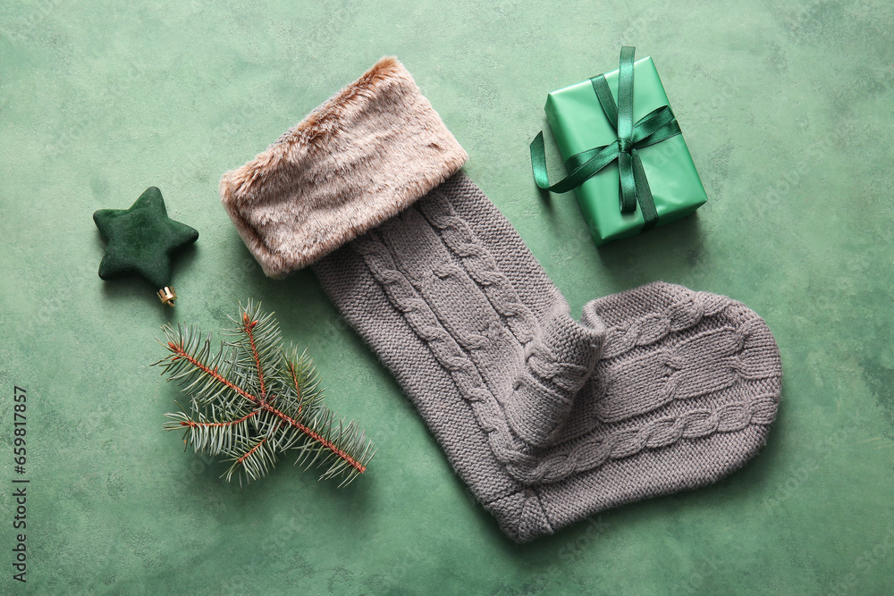 Beautiful Christmas sock with gift box and  decorations on green background