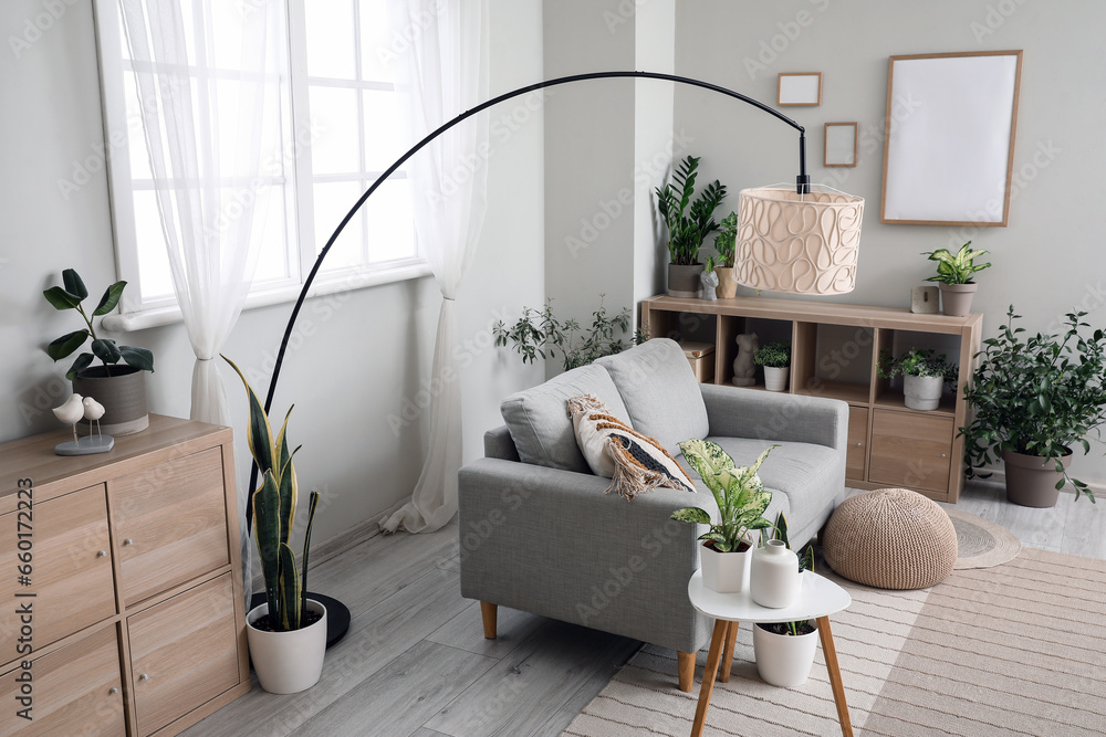 Interior of living room with sofa, lamp and houseplants