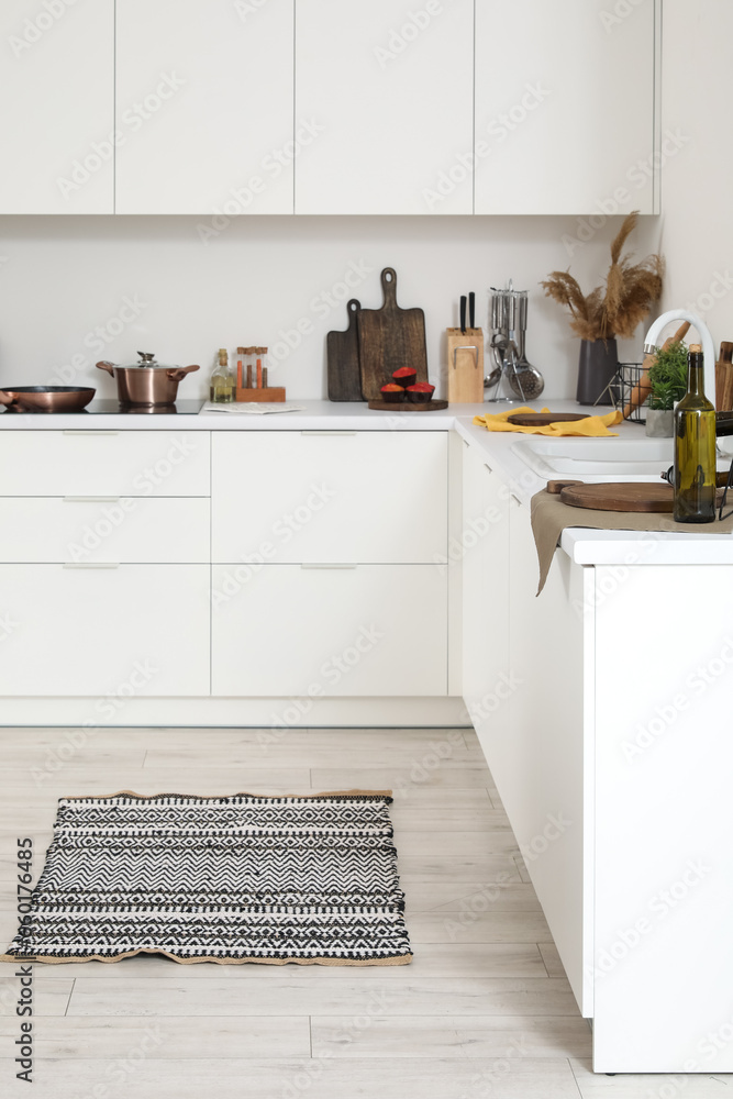 White kitchen countertop with electric stove, cutting boards and utensils