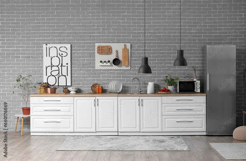 Interior of modern kitchen with white counters and fridge