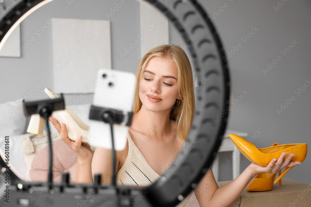 Beautiful young fashion blogger recording video at home about new purchases