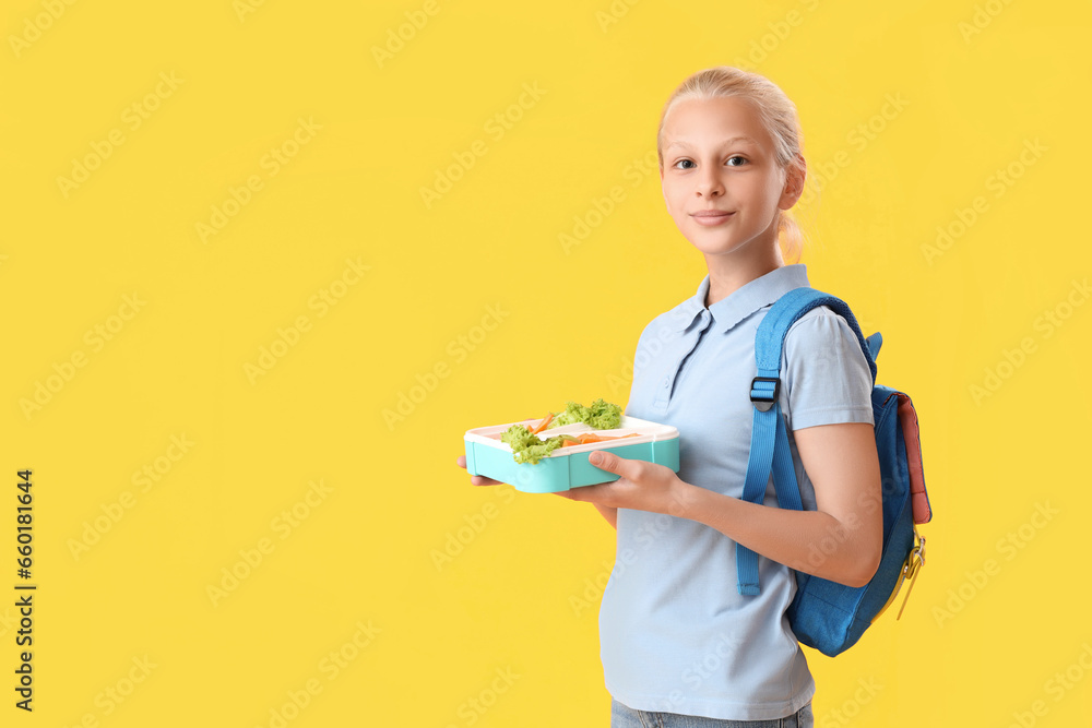 Happy girl with backpack and lunchbox on yellow background