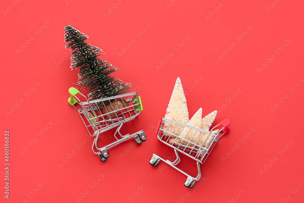 Shopping carts with white and green Christmas trees on red background