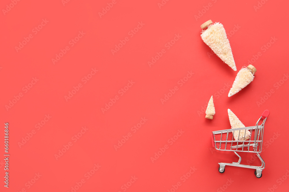 Shopping cart with white Christmas trees on red background