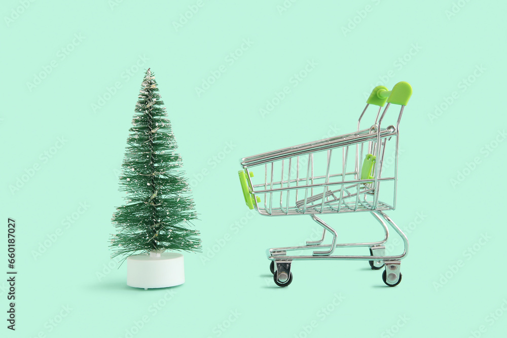 Shopping cart with Christmas tree on green background