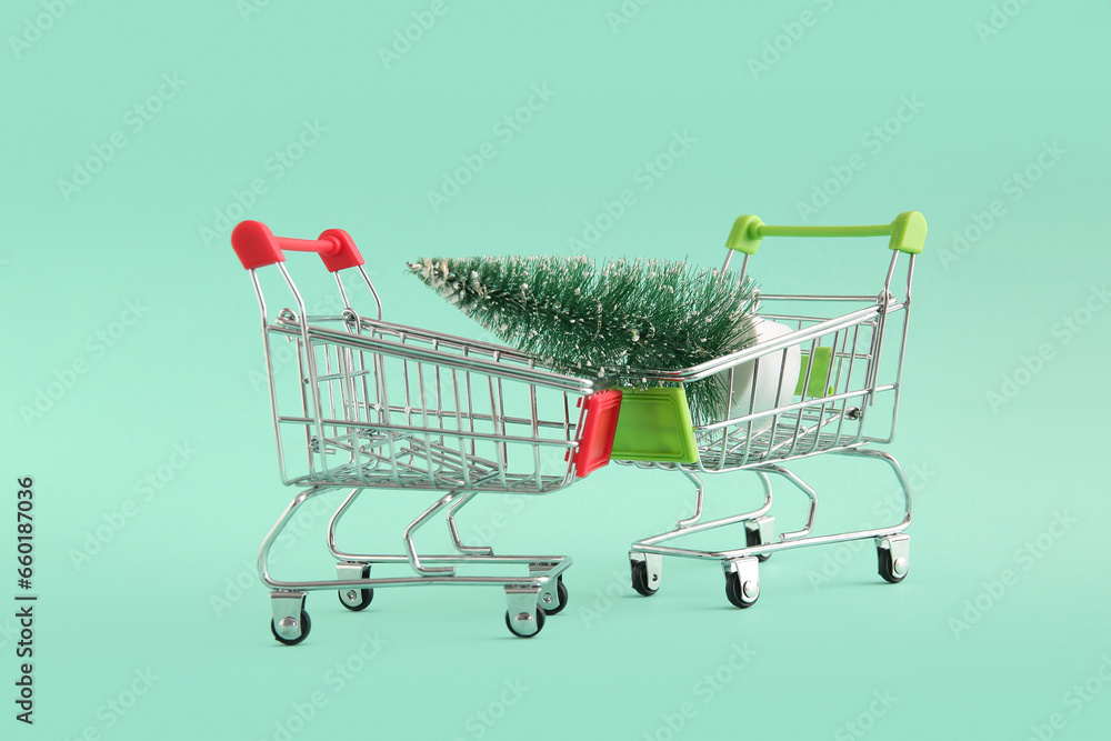 Shopping carts with Christmas tree on green background