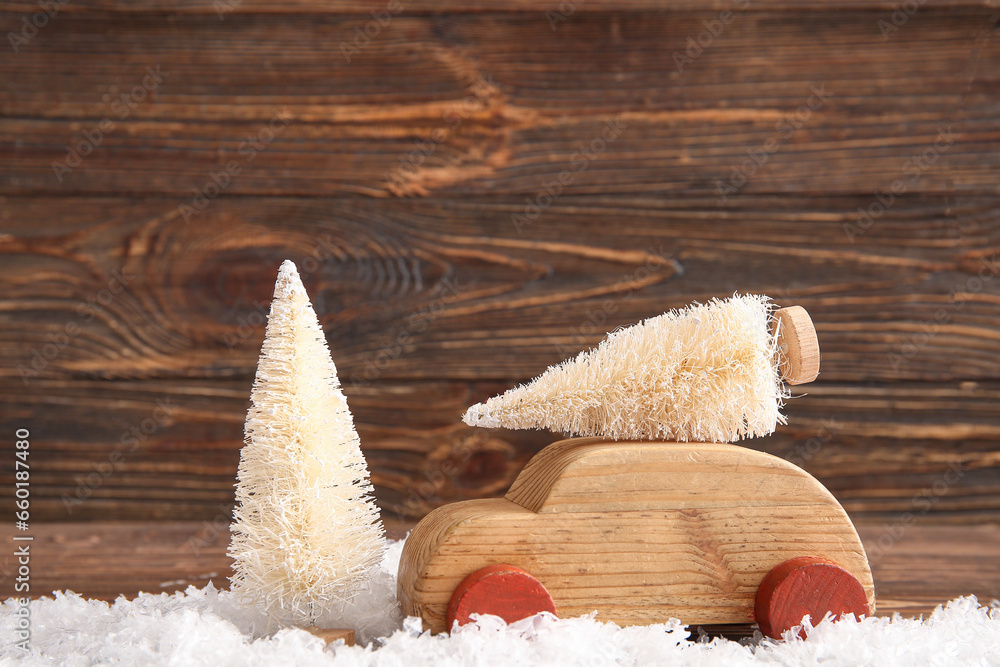 White Christmas trees and toy car on wooden background