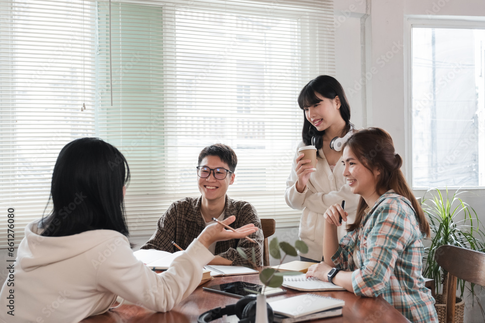 A cheerful and smart young Asian female is standing and sharing her ideas in a meeting with her team. University students, friendship, startups, teamwork