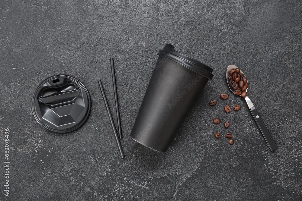 Composition with takeaway paper cup with coffee beans and straws on black background