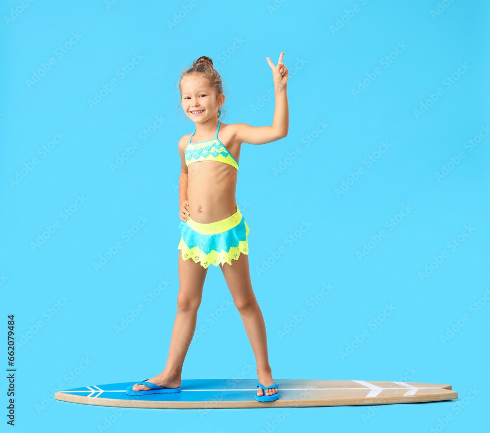 Little girl with surfboard on blue background