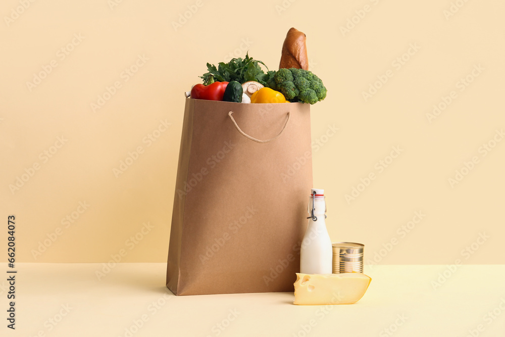 Paper bag with different products on yellow background. Food delivery concept