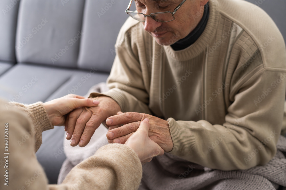 Young woman holding senior man hands, closeup