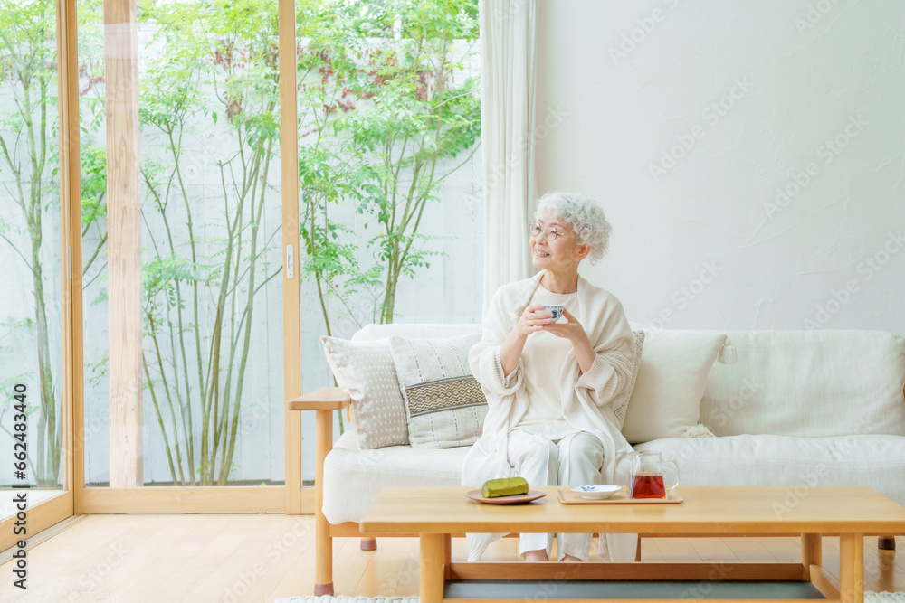 リビングでお茶を飲むシニア女性